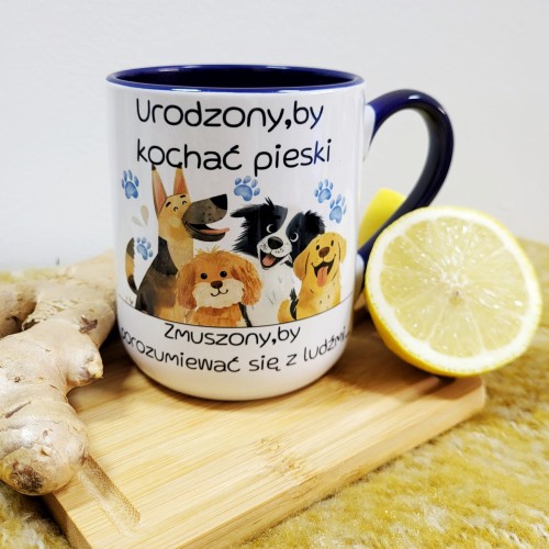 Zbliżenie napisu na kubku: „Urodzony, by kochać pieski – zmuszony, by porozumiewać się z ludźmi”